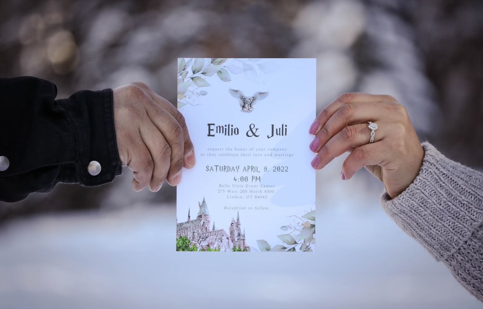 Two hands holding a white wedding invitation card