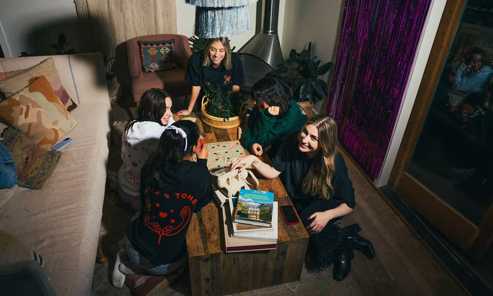 girls sitting around birthday table speaking into audio guestbook phone