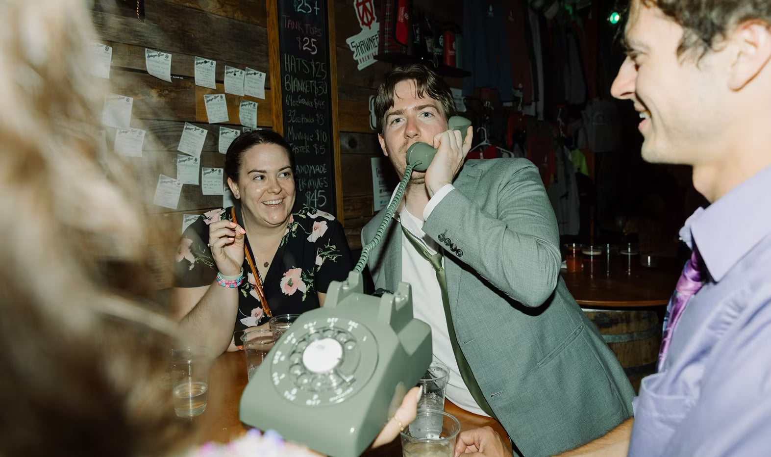 male in suit at corporate event speaking into green phone audio guestbook