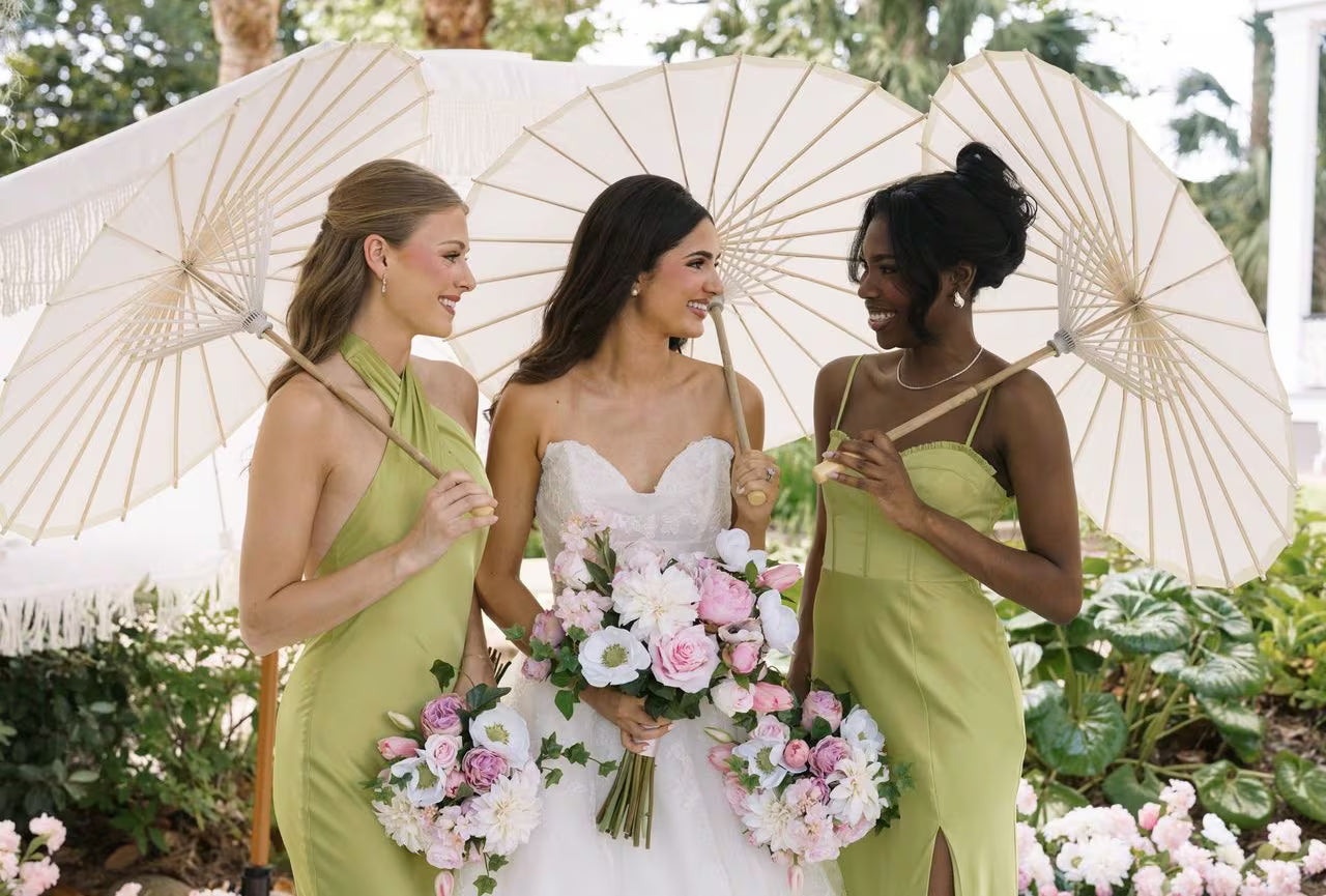 3 girls at wedding holding umbrellas
