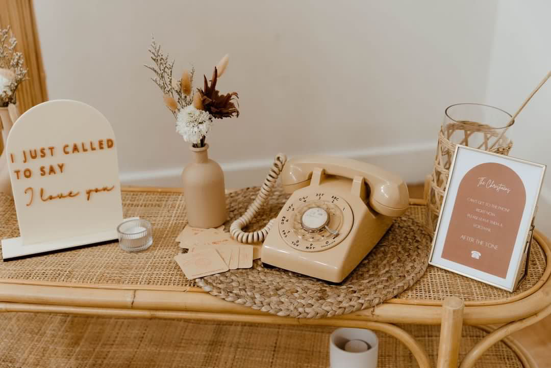 Audio guest book on a welcome table with signage and wedding florals