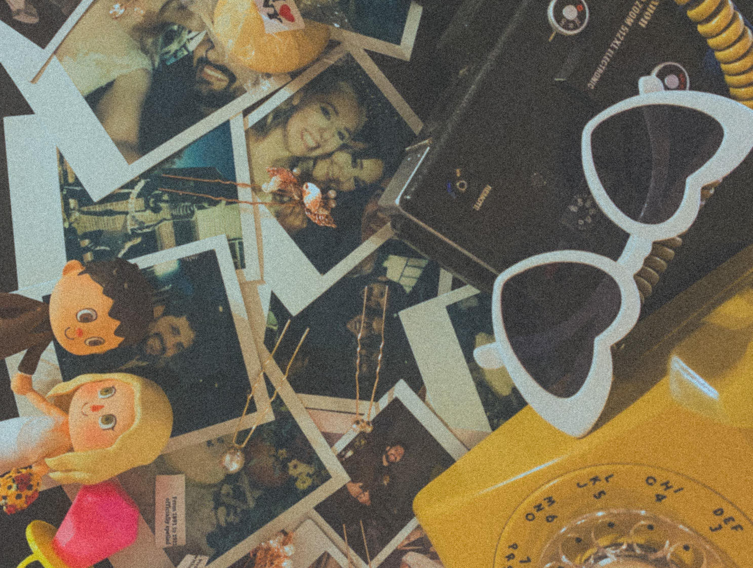 Wedding mementos like sunglasses and polaroids are laid on a wedding table