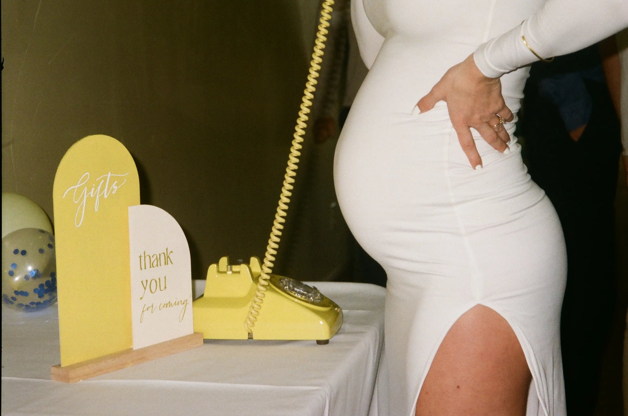 Pregnant expecting mom leaves voicemail on yellow rotary phone at baby shower
