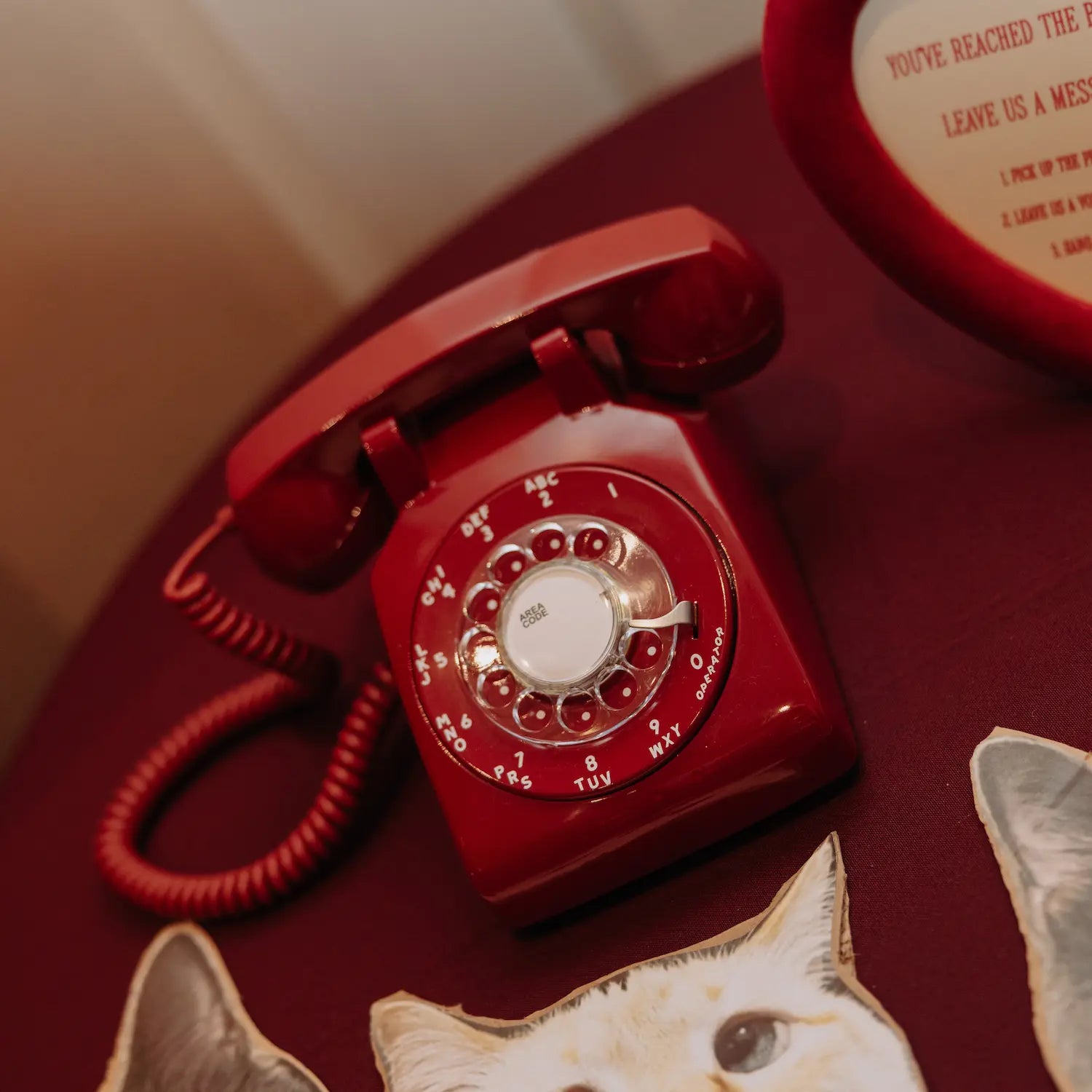 Red phone guest book sits at a guestbook table at real wedding