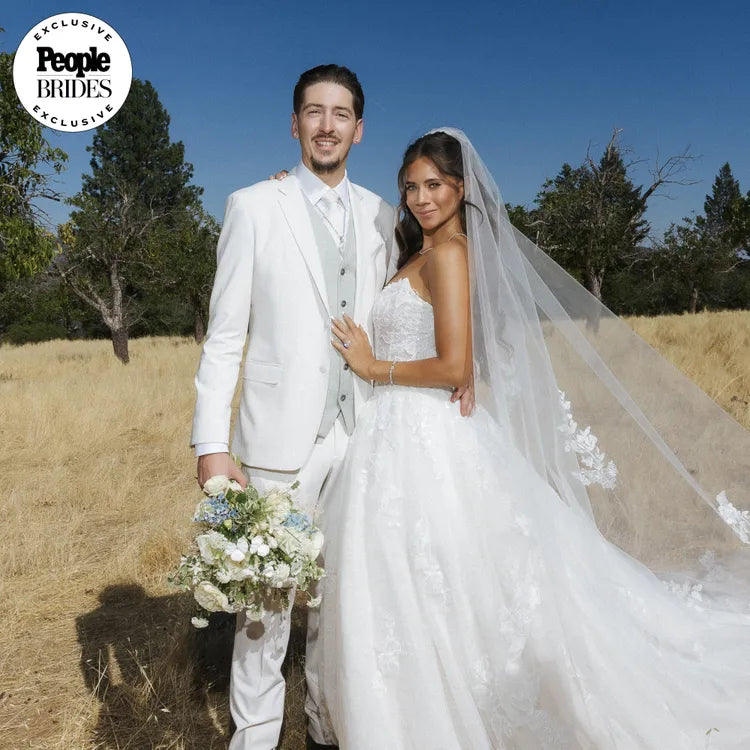 Man and woman in wedding attire standing in a field with 'People' Brides logo.