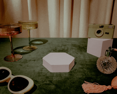 an animated gif video showing a cream rotary phone audio guestbook and various decorations around it on a table and hands interacting with it.