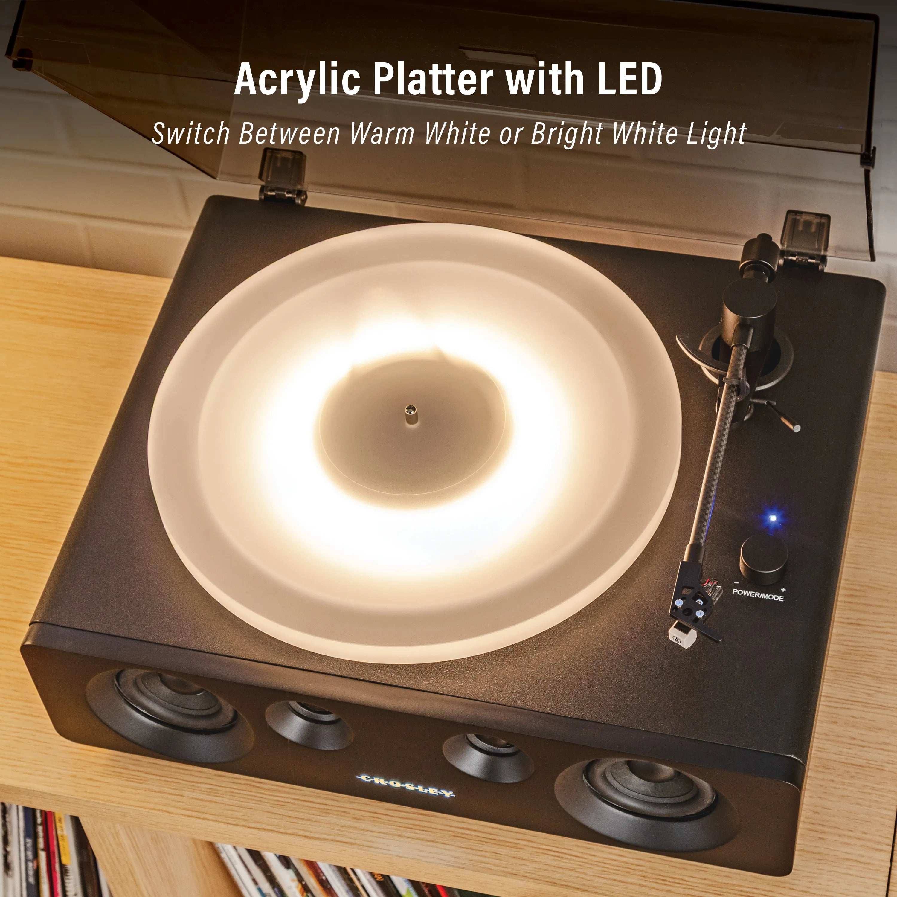 Turntable with acrylic platter and LED light on a wooden surface