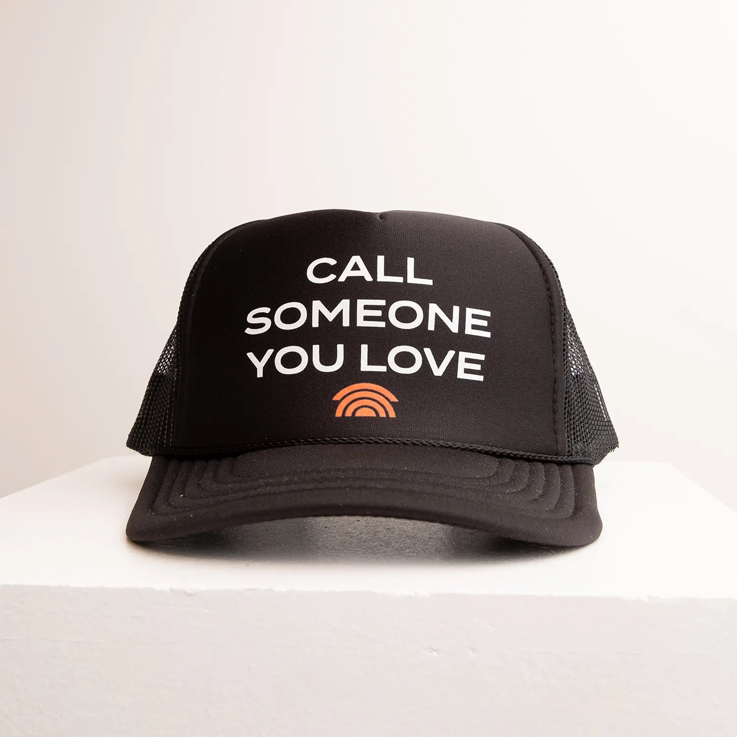 Black cap with 'Call Someone You Love' text on a white background