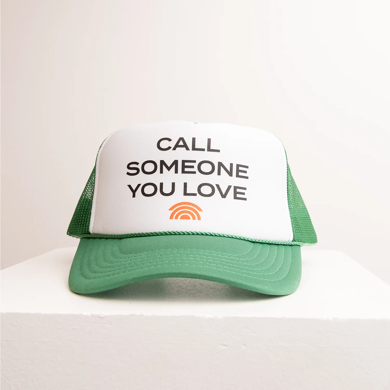 Green and white cap with text 'Call Someone You Love' on a light background