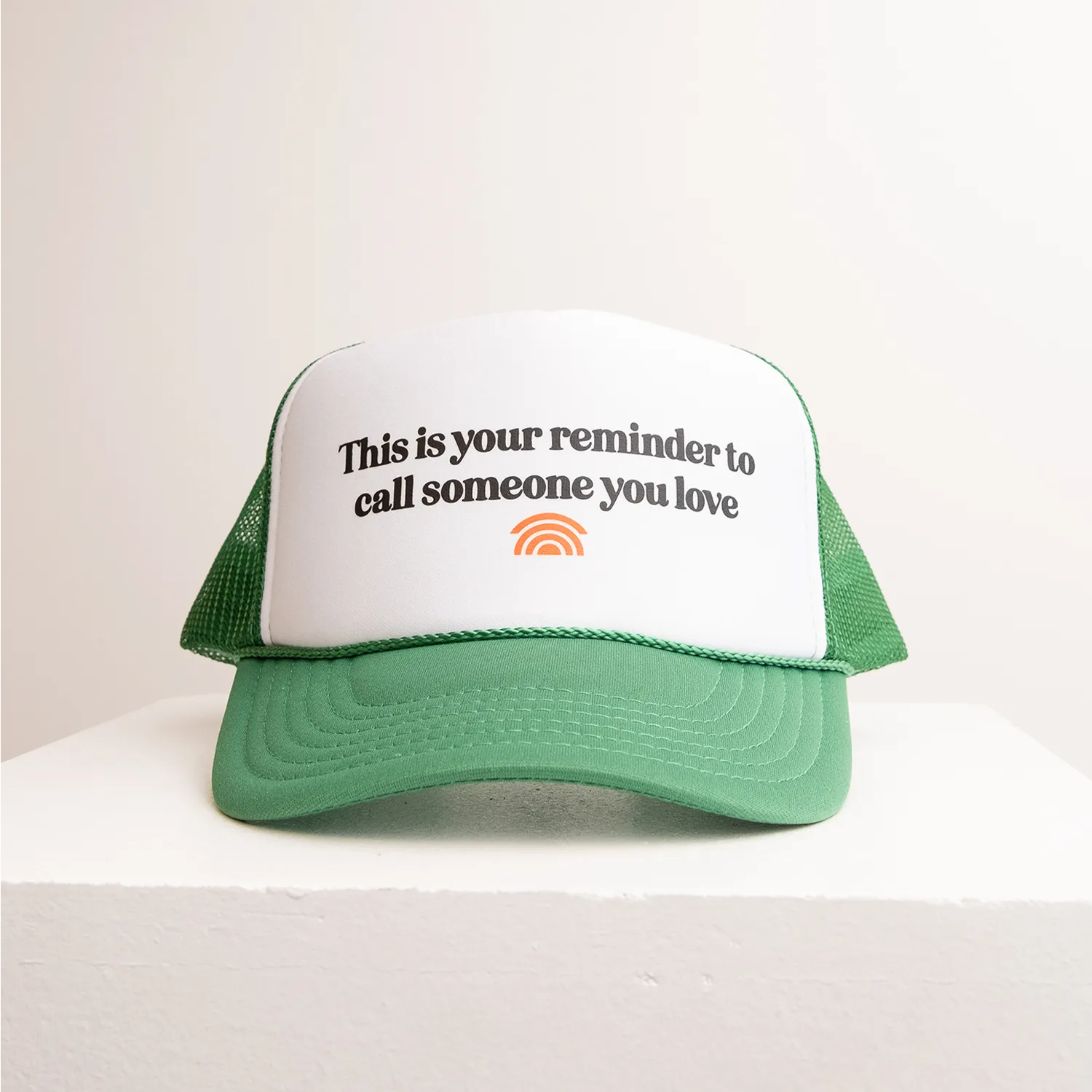 Green and white cap with text and logo on a white background