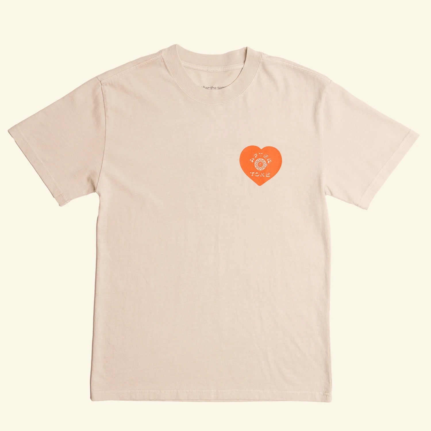 Beige t-shirt with a red heart logo on a beige background