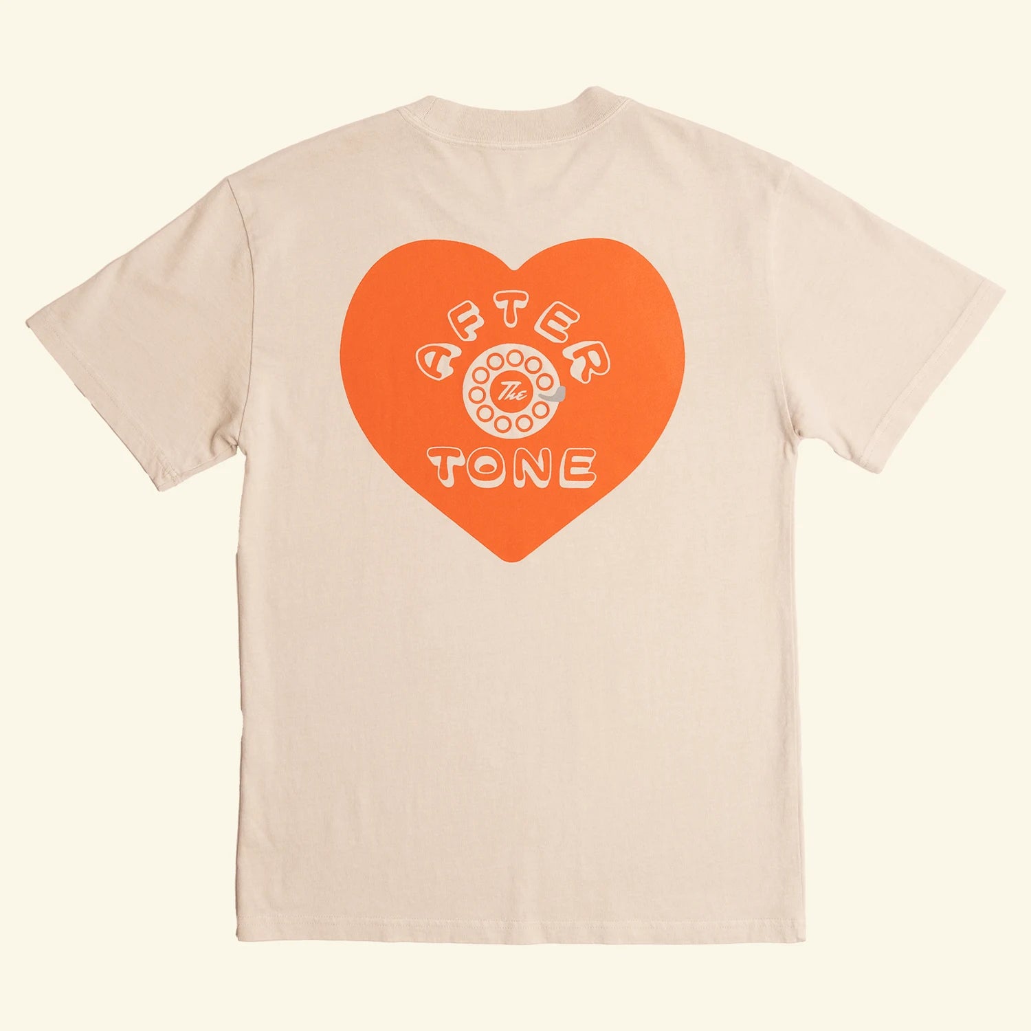 Beige t-shirt with an orange heart-shaped logo on a white background
