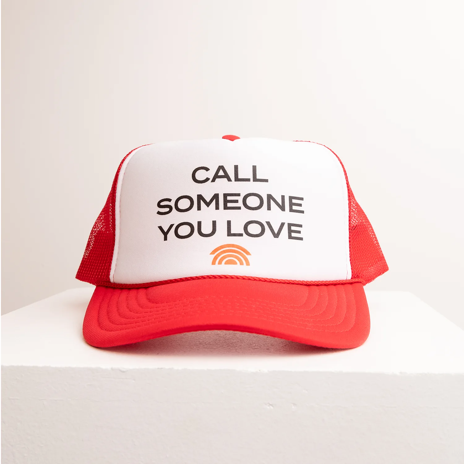 Red and white cap with text 'Call Someone You Love' on a white background