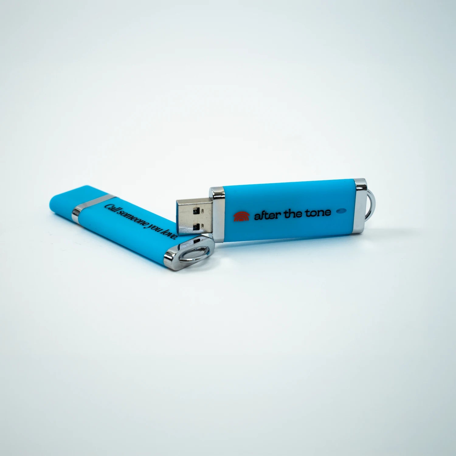 Blue USB flash drive with 'after the tone' branding on a white background
