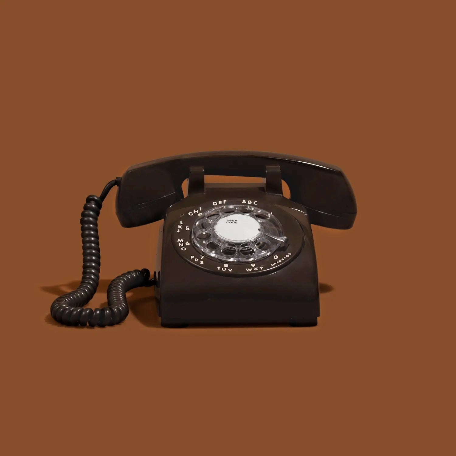 Brown rotary phone on a brown background