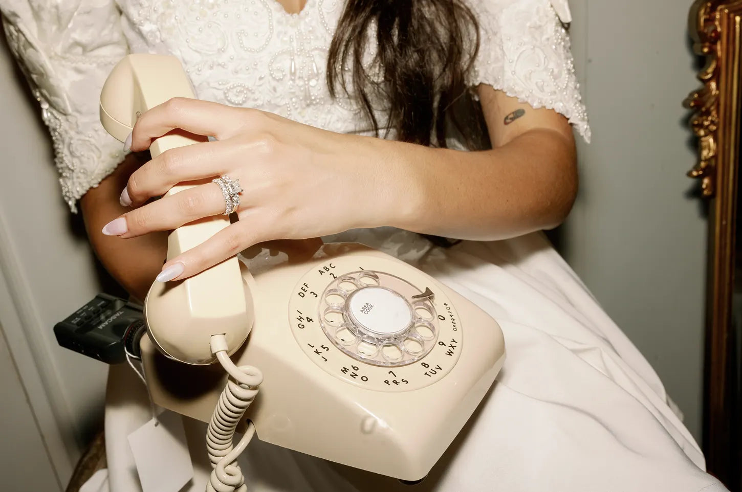 a woman holding a beige rotary phone on her lap