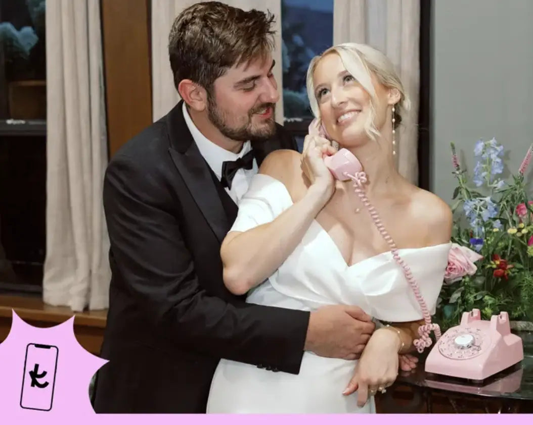a man hugging a woman who is using a pink rotary phone