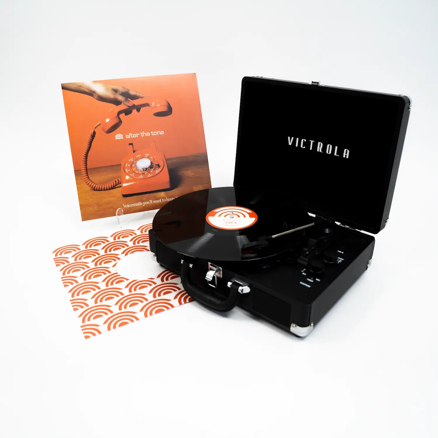 A vinyl record on a record player with a vinyl jacket in the background all on a white background.