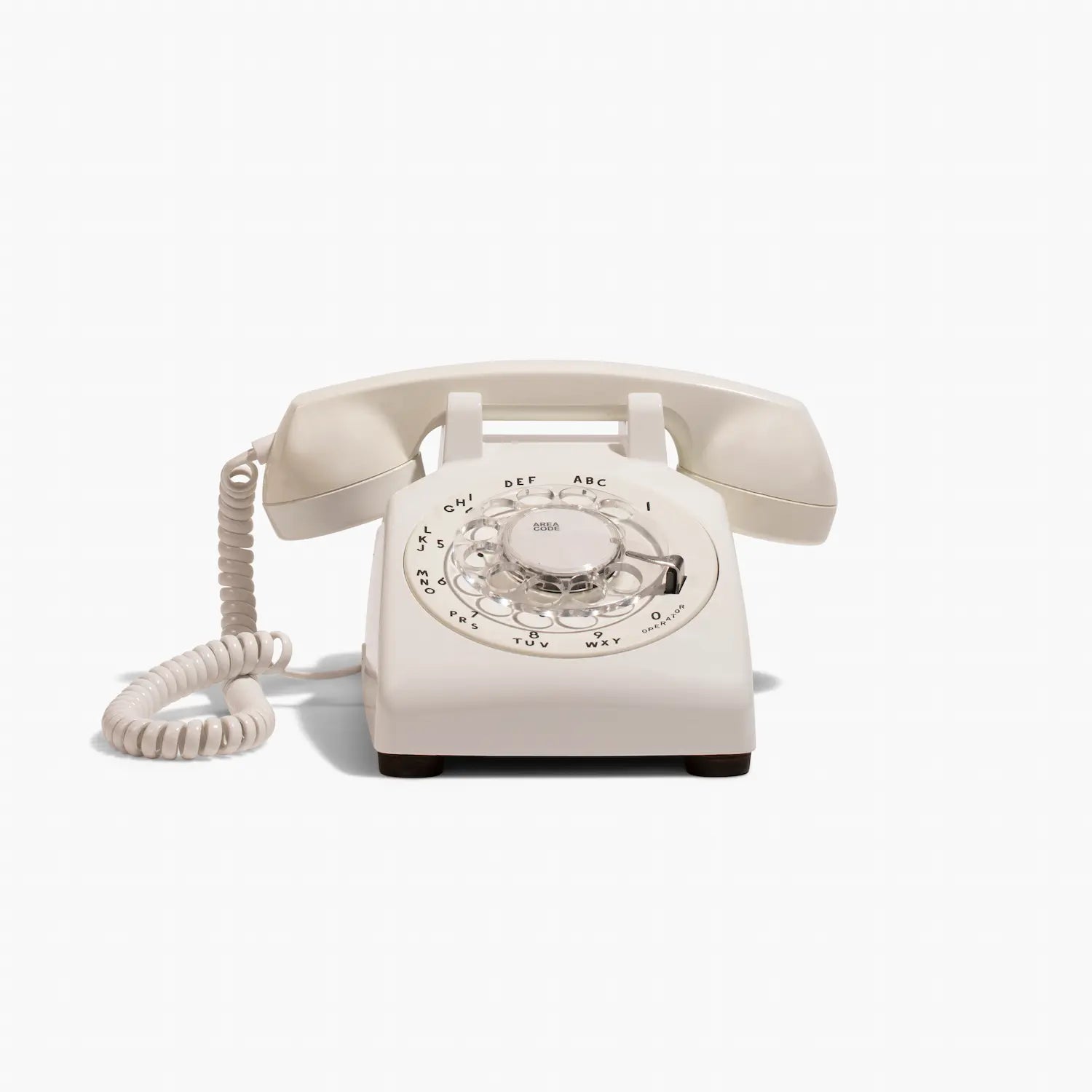 Vintage beige telephone with rotary dial on a white background