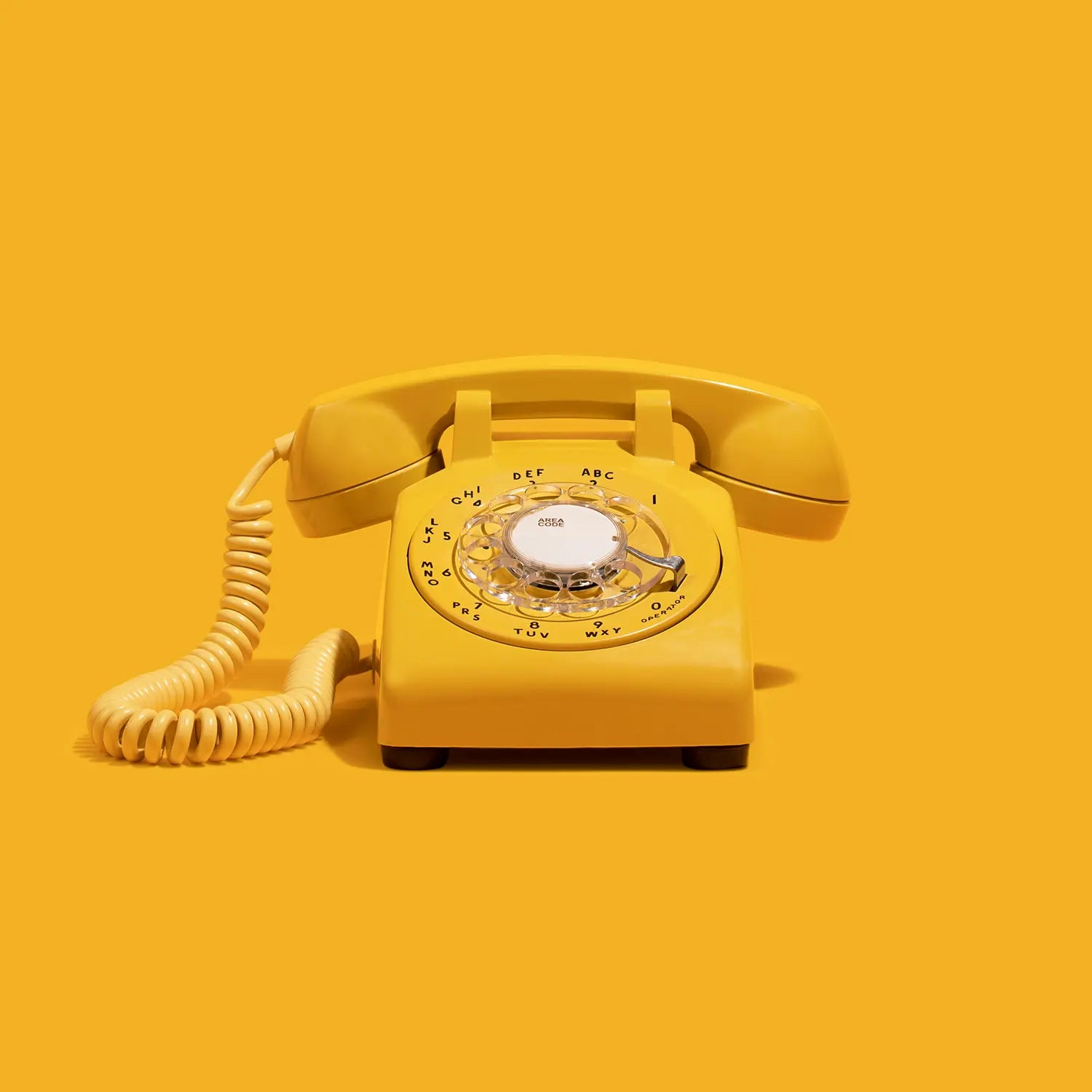 Yellow rotary phone audio guestbook on a yellow background